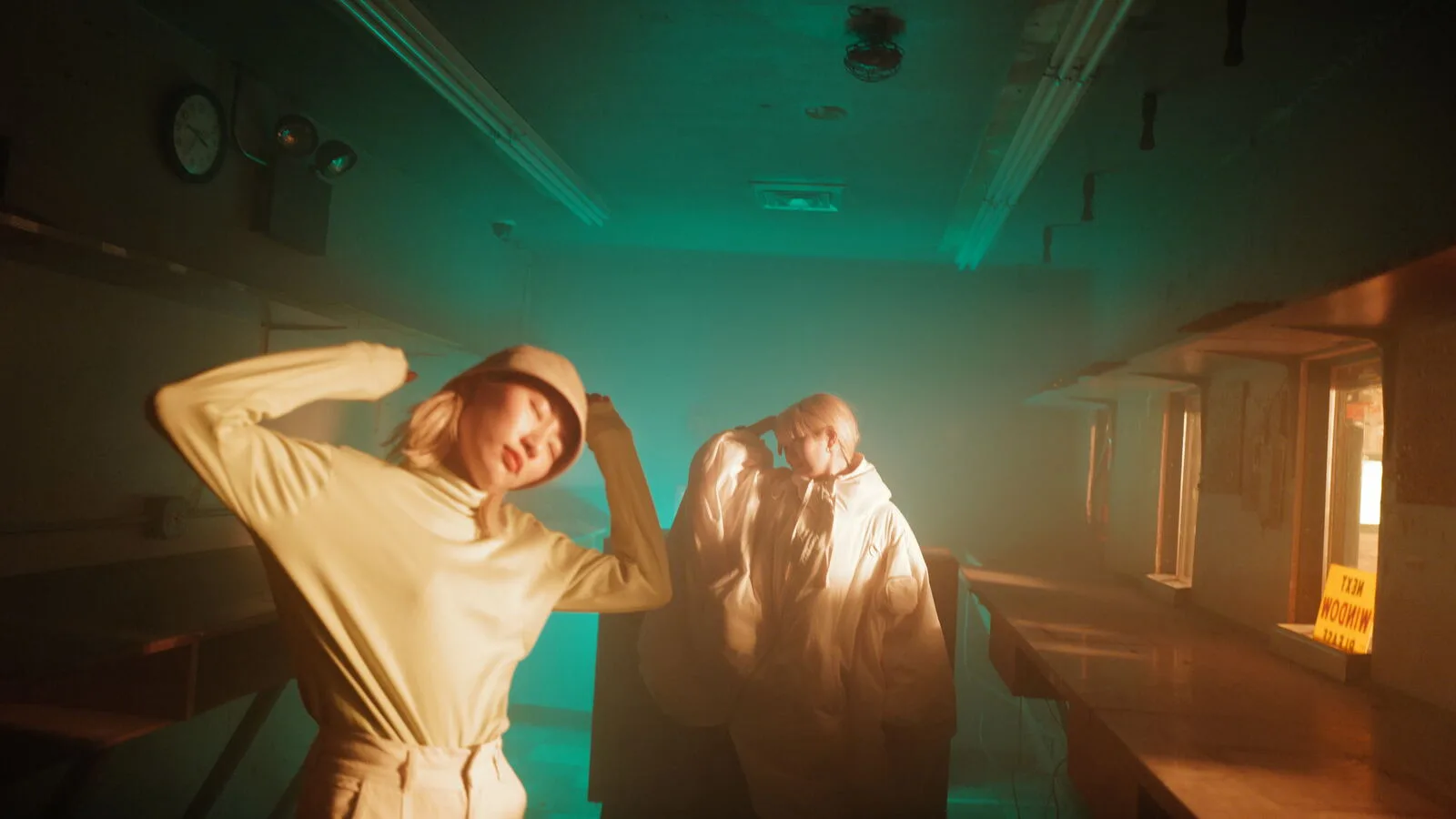 Two people in a green-lit corridor