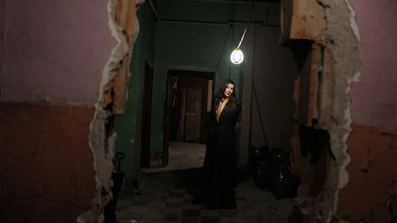 A singer standing in a dim room under a single bulb